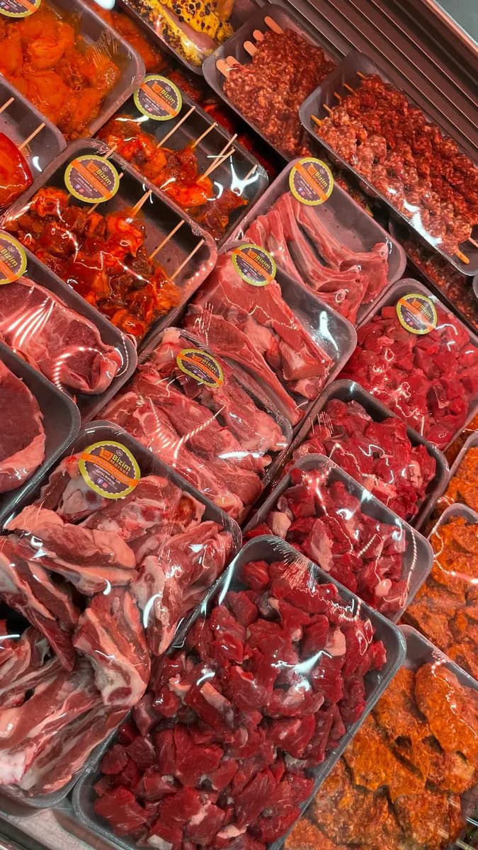 Fleischtheke von oben mit marinierten Spießen, Lammkoteletts, Gulasch und Köfte.
