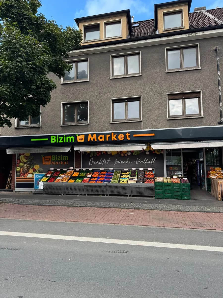 Bizim Market von der Straße aus: Leuchtschrift über der Obstauslage vor dem Haus.