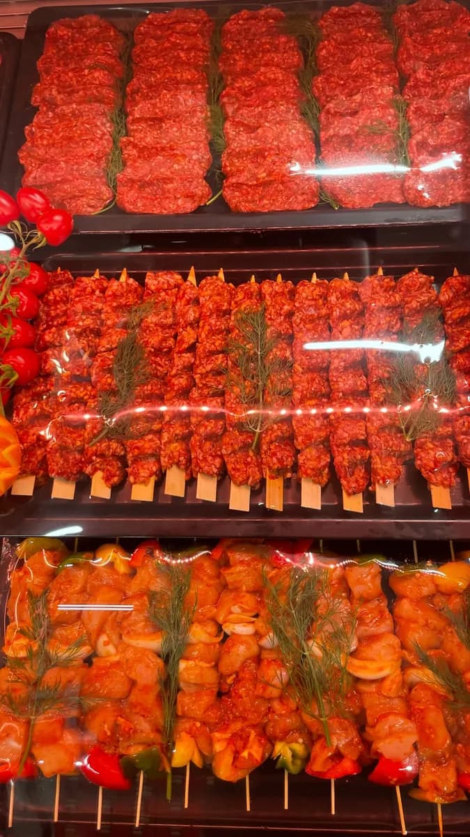 Platten mit Köfte, Adana-Spießen und Hähnchenschaschlik, dekoriert mit Dill und Tomaten.