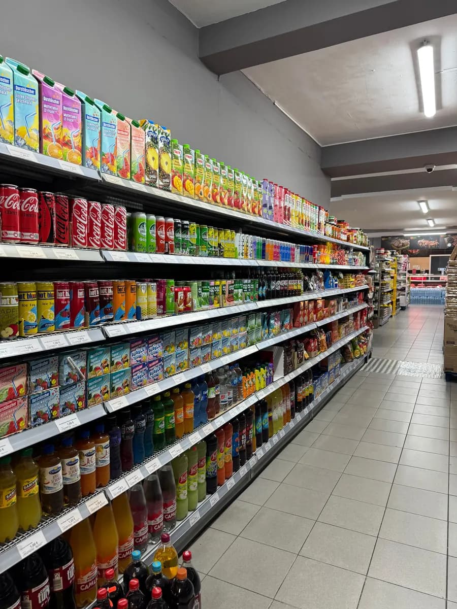 Getränkegang mit Säften, Limonaden und Wasser in Flaschen und Kartons.
