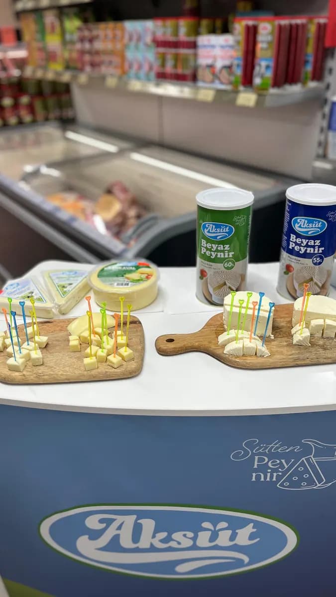 Verkostungsstand von Aksüt mit Käsewürfeln auf dem Holzbrett und Bechern Beyaz Peynir.