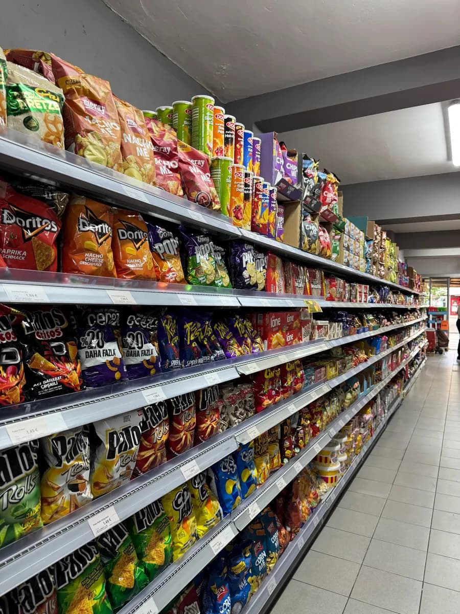 Langer Gang mit Chips, Knabbereien und Süßem in bunten Tüten.