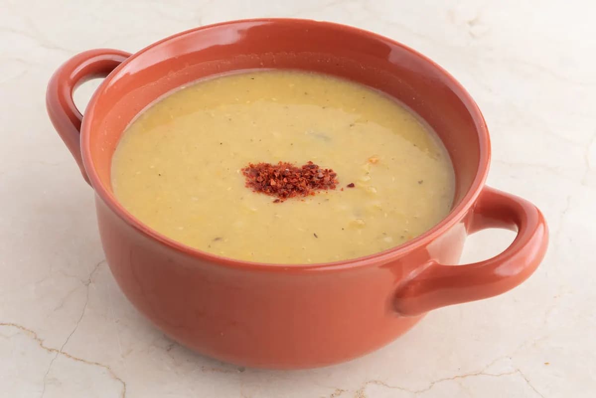 Cremige rote Linsensuppe mit Paprikaflocken in einer Schale